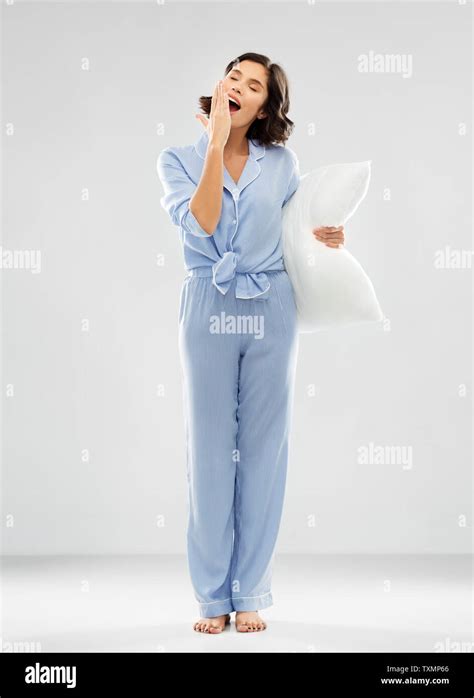 Sleepy Woman In Pajama Holding Pillow And Yawning Stock Photo Alamy