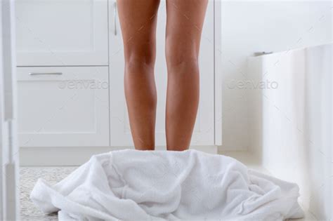 Caucasian Woman Standing Naked In Bathroom With Bathrobe On The Floor