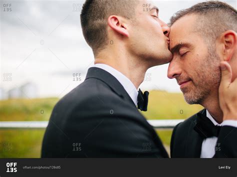 Man Kissing His Partner On Their Wedding Day Stock Photo Offset