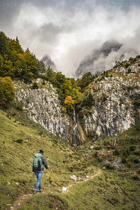 Woman With Dog Hiking In Kaiser Mountains Tyrol Austria Stock Photo