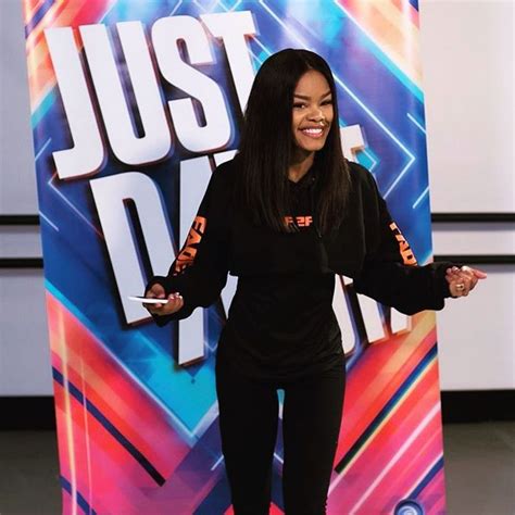 A Woman Standing In Front Of A Just Dance Sign With Her Hands Out To
