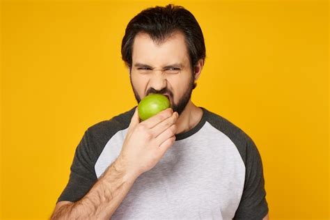 Premium Photo Adult Bearded Man Eats Green Apple