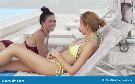Two Beautiful Women Smiling To The Camera While Resting On The Beach Stock Image Image Of