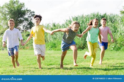 Niños Trotando Juntos En El Parque Y Divirtiéndose Imagen De Archivo