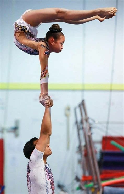 Two Women Doing Acrobatic Tricks On The Balance Beam