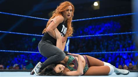 Two Women Wrestling On The Floor In Front Of An Audience