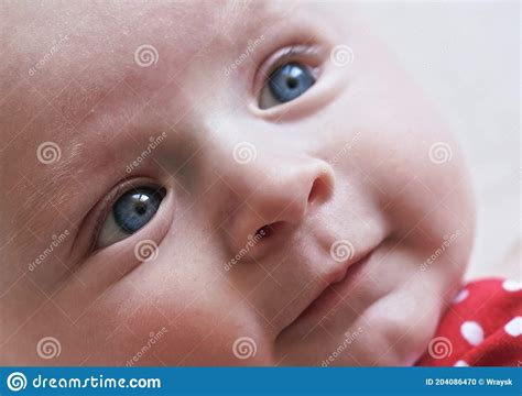 Infant Baby Boy Closeup Detail On Face With Bright Blue Eyes Stock