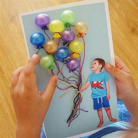 A Person Holding Up A Card With Balloons Attached To The Back Of It And