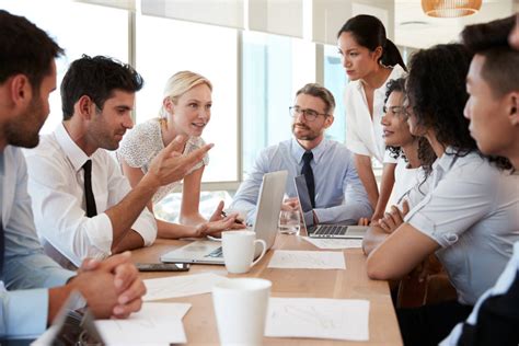 Group Of Businesspeople Meeting Around Table In Office Absolute