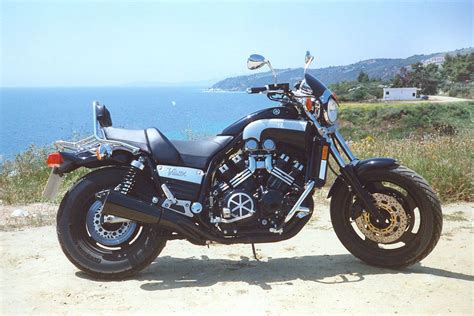 A Black Motorcycle Parked On Top Of A Dirt Road Next To The Ocean And