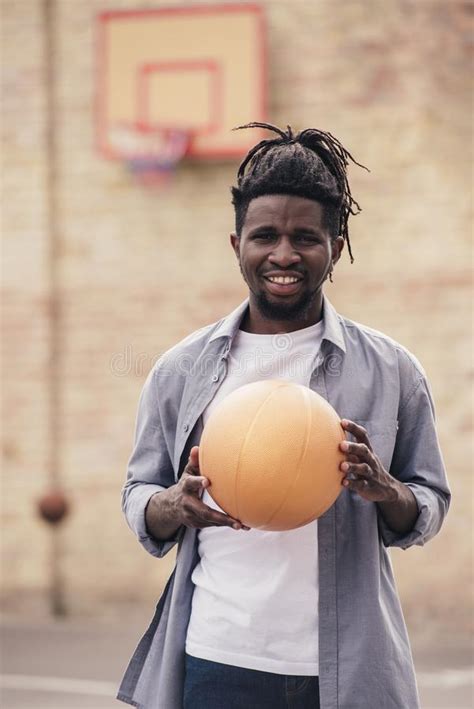 Smiling African American Man Holding Basketball Ball Stock Photo