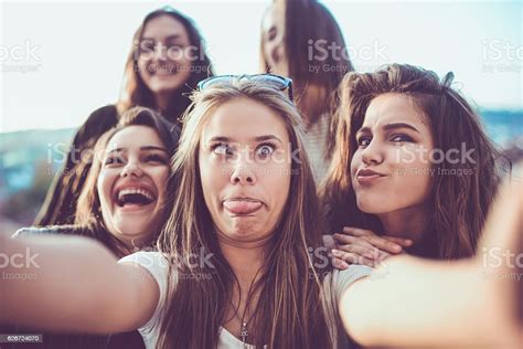 Group Of Crazy Girls Taking Selfie And Making Faces Outdoors Stock