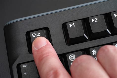 Finger Pushing Esc Key On Black Keyboard Stock Photo Download Image