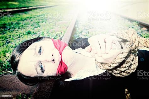 Desperate Bound And Gagged Businesswoman Lying On Railroad Track Stock