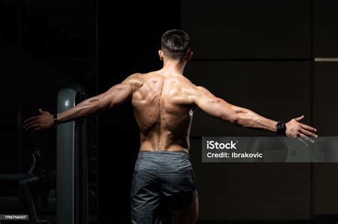 Hombre Musculoso Flexionando Músculos De La Espalda Pose Foto De Stock