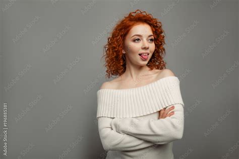 Fotografia Do Stock Young Cute Redhead Curly Haired Girl Shows Her Tongue Teasing Adobe Stock