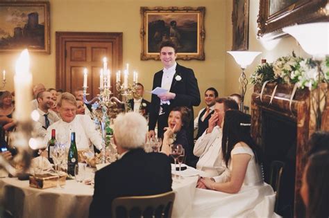 A Group Of People Sitting Around A Table With Wine Glasses And Candles