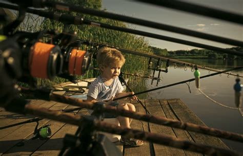 Kid Play Little Baby Boy Fishing On Bank Of River With Fishing Rod