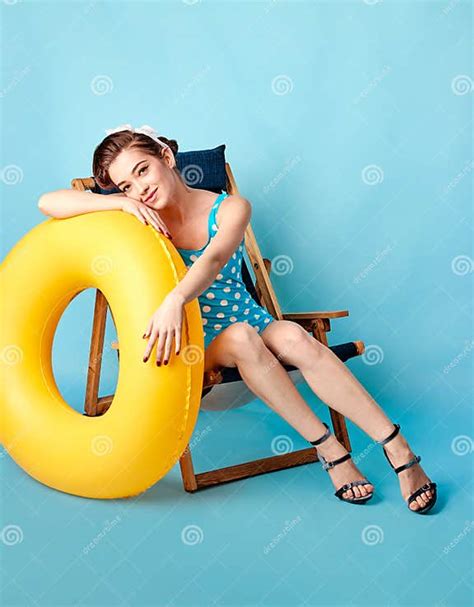 Girl In A Bathing Suit Lying On A Lounger And Holding In Her Arms An Inflatable Circle Stock
