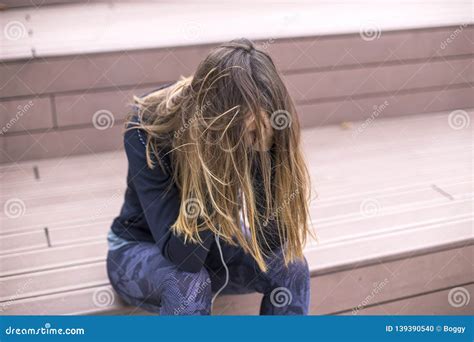 Worried Sad And Depressing Young Woman Sits Outside Stock Photo