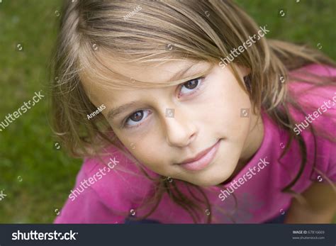 Close Up Portrait Of A Ten Year Old Girl Smiling Up At The Camera
