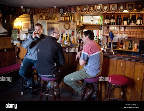 Three Men Drinking And Talking In A Bar The Jolly Sailor Pub Stock