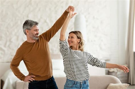 Premium Photo Middle Aged Husband And Wife Dancing Having Fun At Home