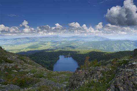 View From The Top Of The Mountain To The Blue Lake Surrounded By