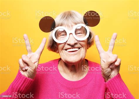 Elderly Woman Wearing Big Sunglasses Laugh And Showing Peace Or Victory