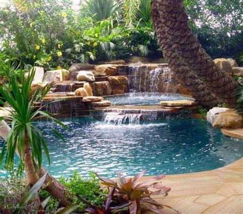 An Outdoor Pool With Waterfall And Palm Trees