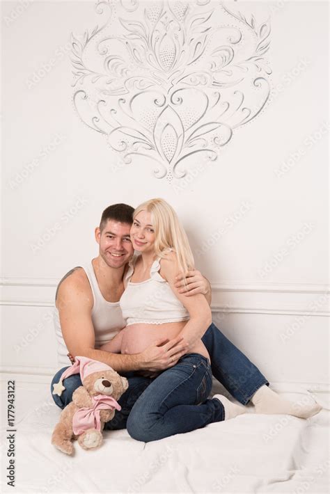 Beautiful Pregnant Couple In Love On The Background Hands Of Husband On The Tummy Of His