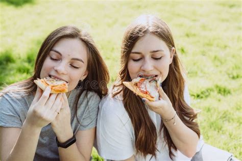 Two Cheerful Young Teen Friends In The Park Eating Pizza Women Eat Fast Food Not A Healthy