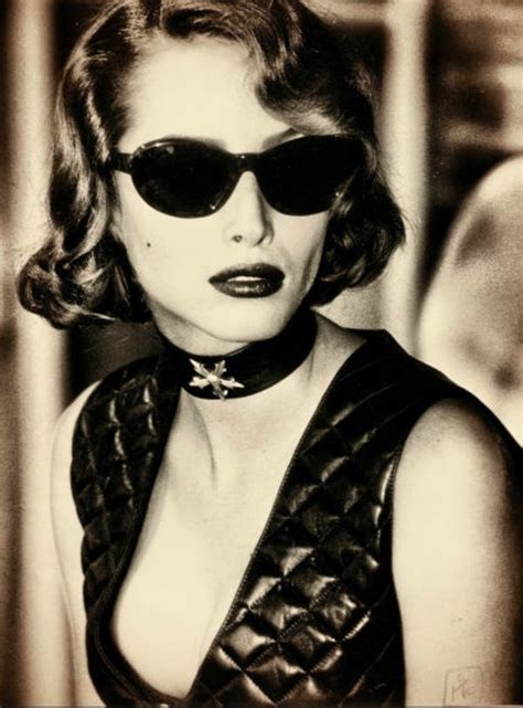 black and white photograph of a woman with sunglasses on her head wearing a leather dress