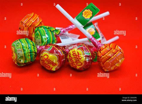a handful of bright colorful popular sucking candy round candies with a white plastic stick