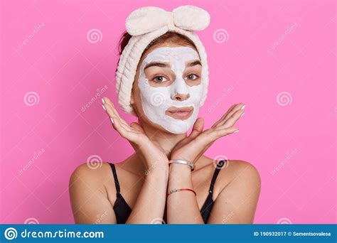 Adorable Woman Has Glad Look Keeps Hands Under Chin Looks Directly At