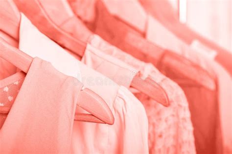 Coral Womens Clothes On Hangers On Rack In Fashion Store Closet Stock