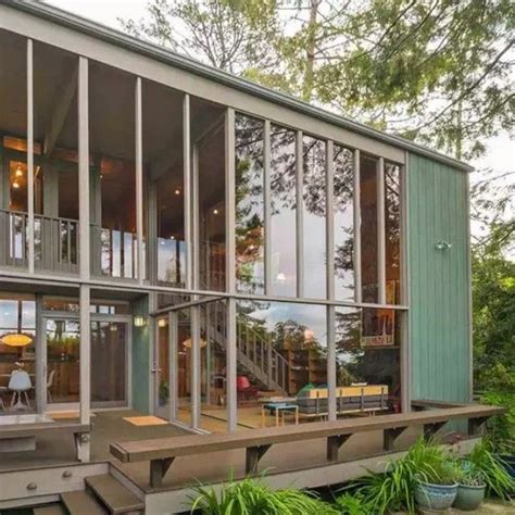 A House That Is Sitting In The Middle Of Some Grass And Trees With Lots