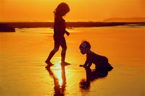 enfants jouant avec l amusement sur la plage de mer de coucher du soleil image stock image du