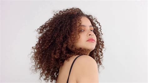Mixed Race Black Woman With Freckles And Curly Hair Turning To The Camera And Touches Her Big