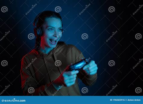 The Gamer Happy Smiling Girl With Headphones And Joystick Playing Video