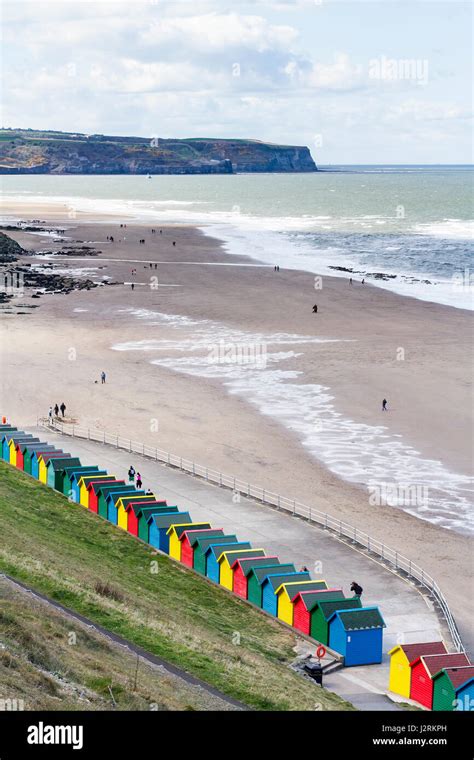 Row Of Brightly Coloured Wooden Beach Huts Along The West Cliff