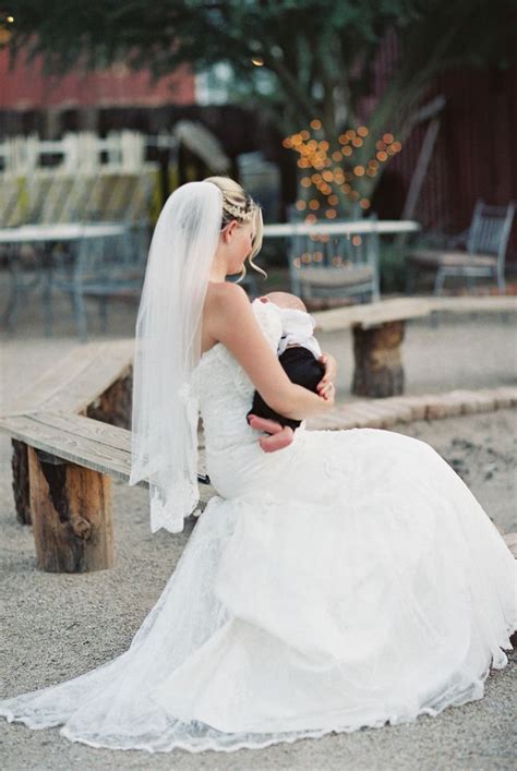 A Woman In A Wedding Dress Sitting On A Bench