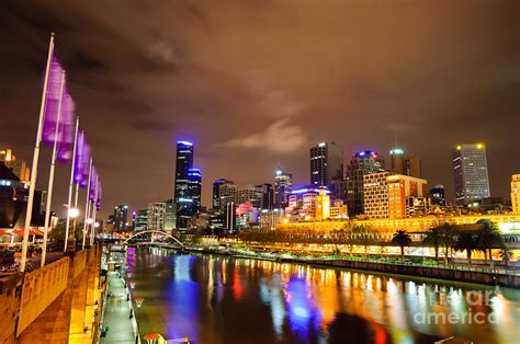 State government considers tighter restrictions as more than 70 exposure sites listed, including afl stadiums and bars. Night view of the Yarra River and skyscrapers - Melbourne - Australia Photograph by David Hill
