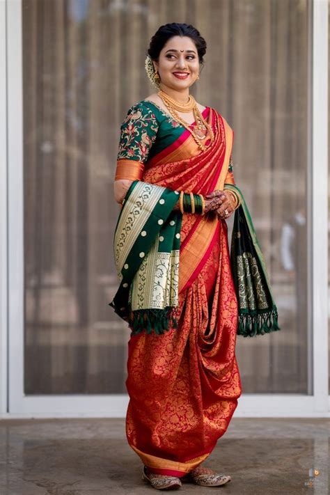 A Woman In An Orange And Green Sari Is Standing With Her Hands On Her Hips