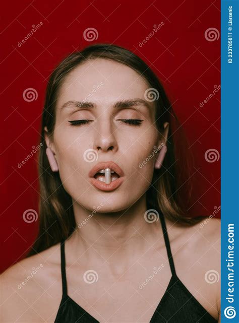 Young Woman With Capsule On Lips Isolated On Red Wall Stock Image Image Of Addiction