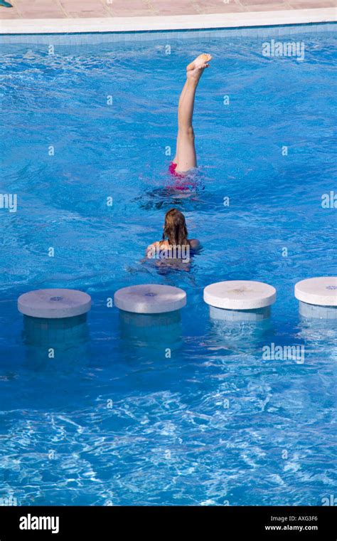 espagne ibiza 10 13 ans fille femme enfant jouant doing handstand dans une piscine smiling