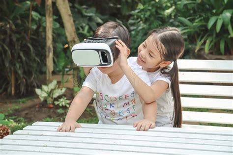 Kids Sister Holding Virtual Reality Vr For Boy Younger Brother To Play