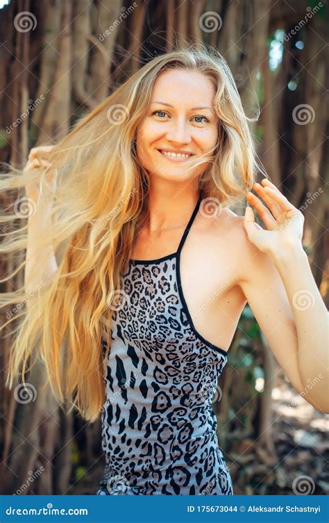porträtt av en ung vacker flicka med långt hår på suddig naturlig bakgrund sexig blond leende