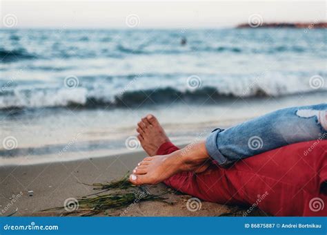 Young Couple Cuddling On The Beach Close To The Water Legs Entwined Stock Image Image Of