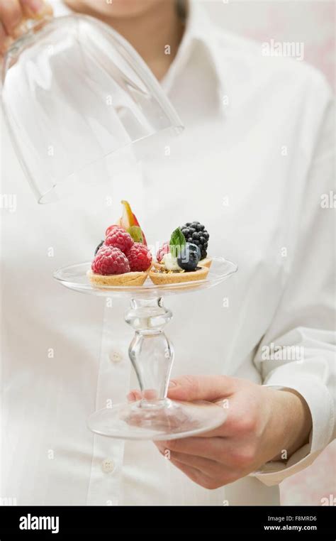 Woman Serving Assorted Berry Tarts Stock Photo Alamy